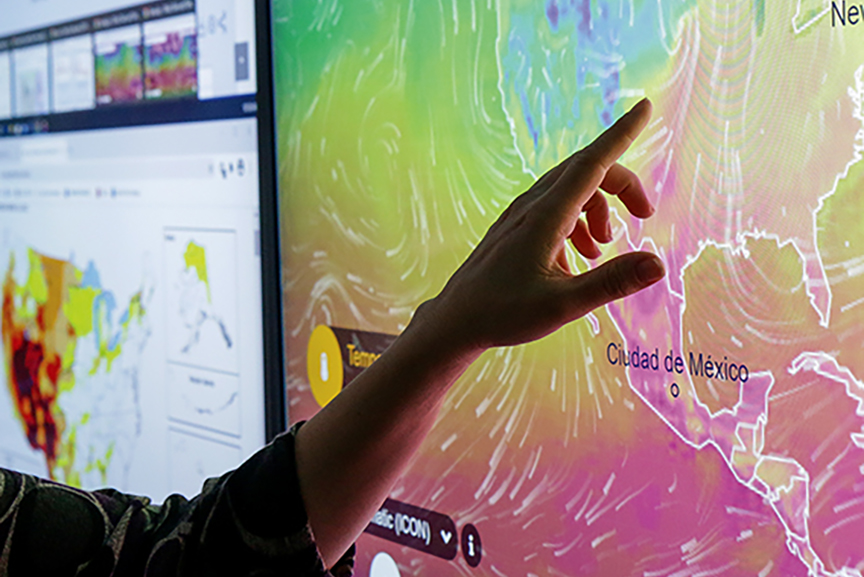 Hand in front of a large illuminated map